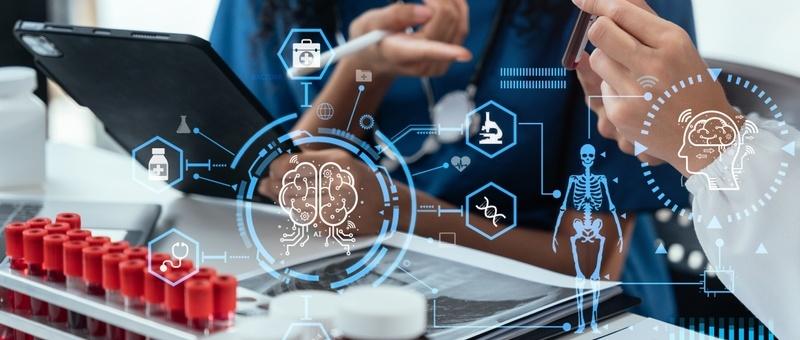 Healthcare professional using digital tablet with medical technology icons and digital overlays of brain and skeleton.