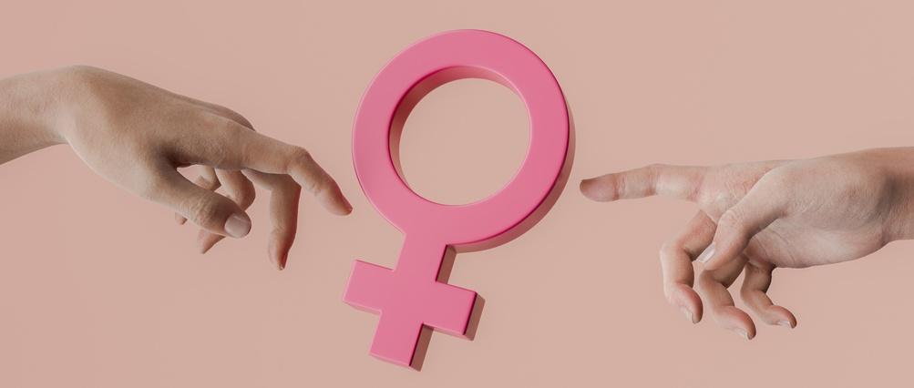 Two hands pointing at a pink female gender symbol promoting women's rights and gender equality.