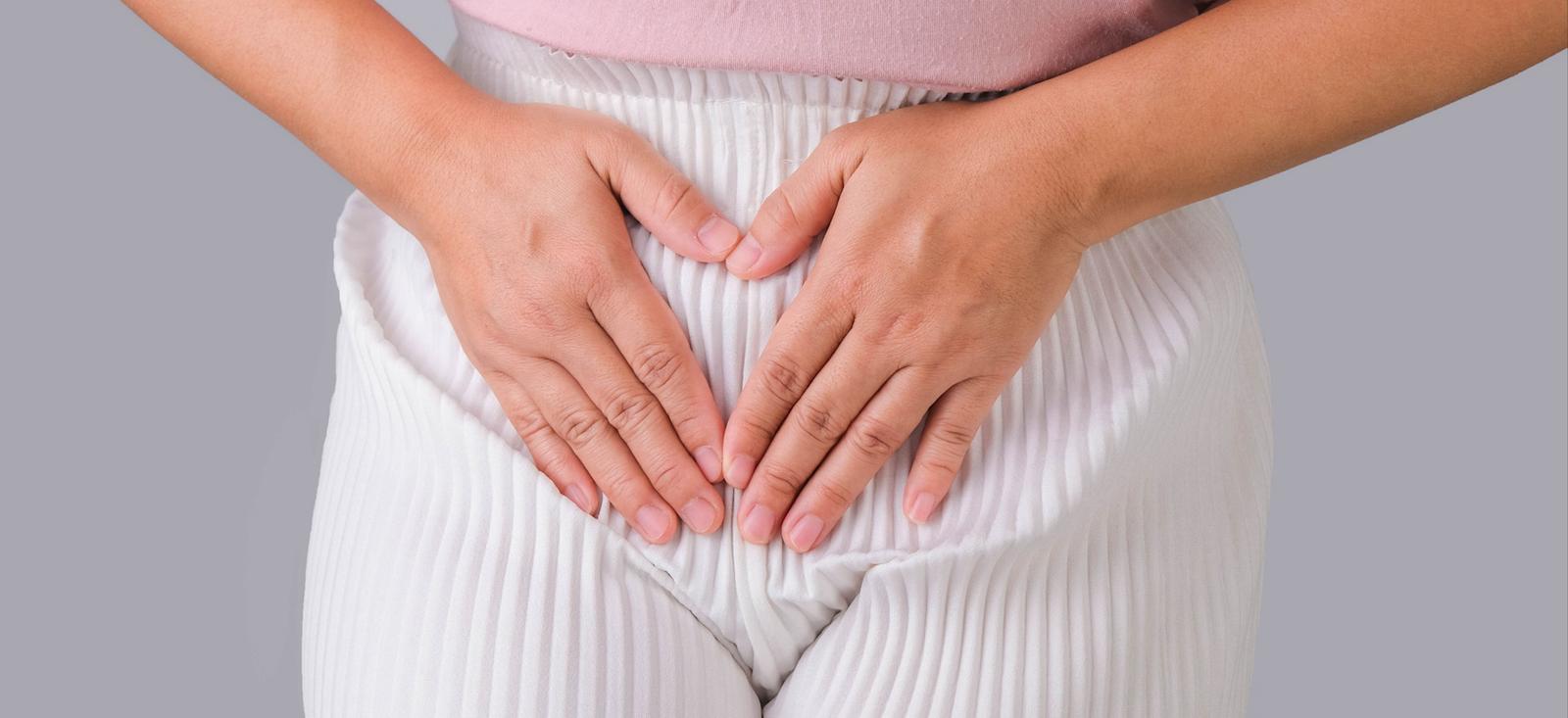 A close up of a female holding her pelvis.