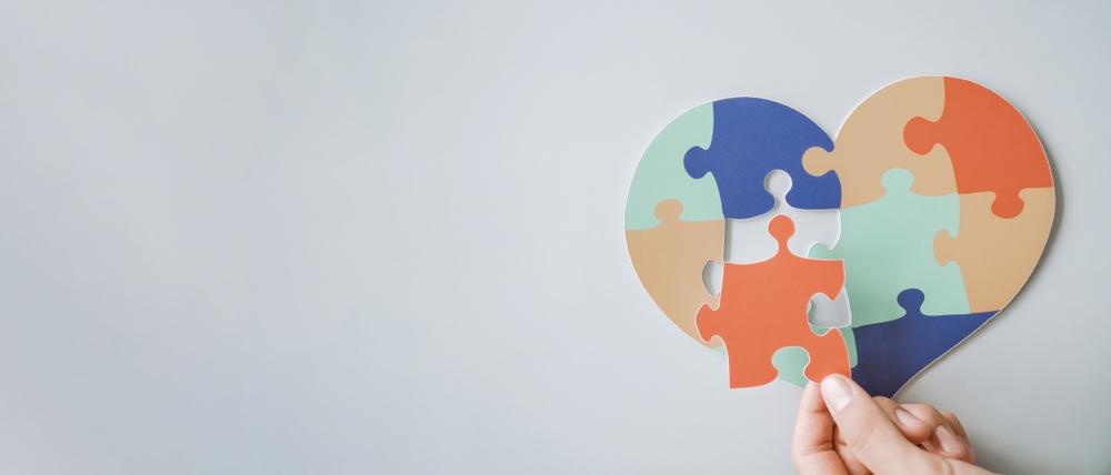 Jigsaw heart - assorted colours against pale blue background.