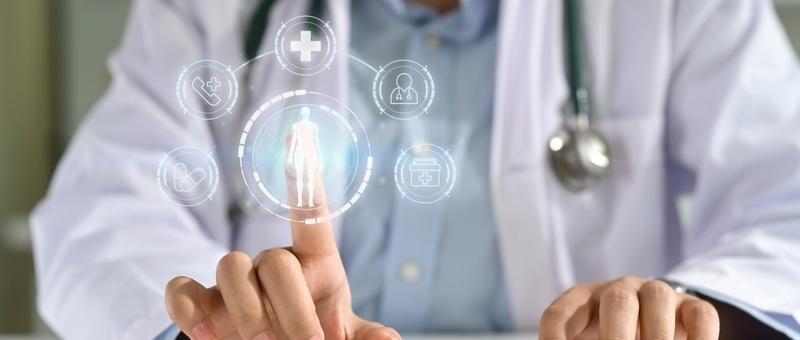 Doctor with stethoscope touching digital healthcare interface showing human figure and medical icons.