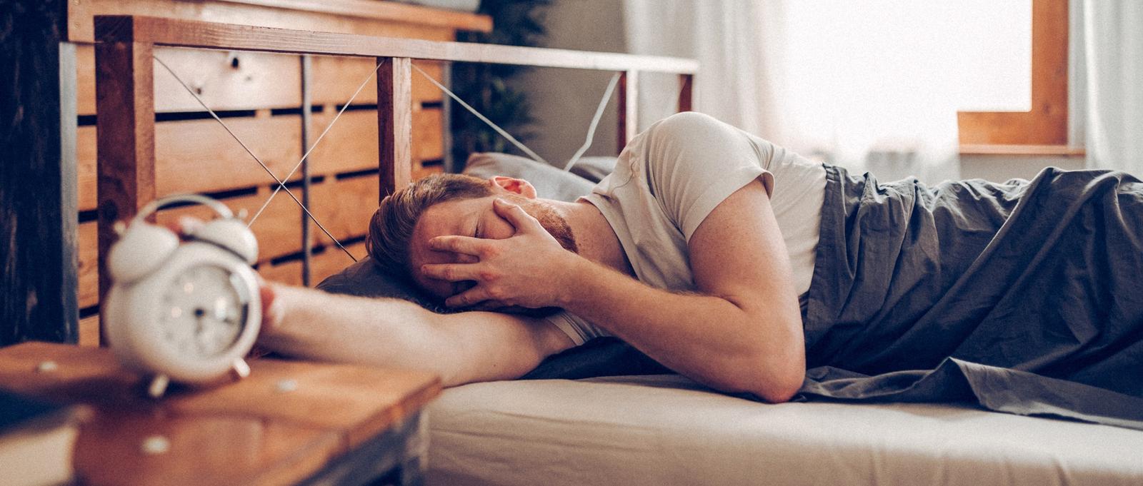 Men in bed looking tired