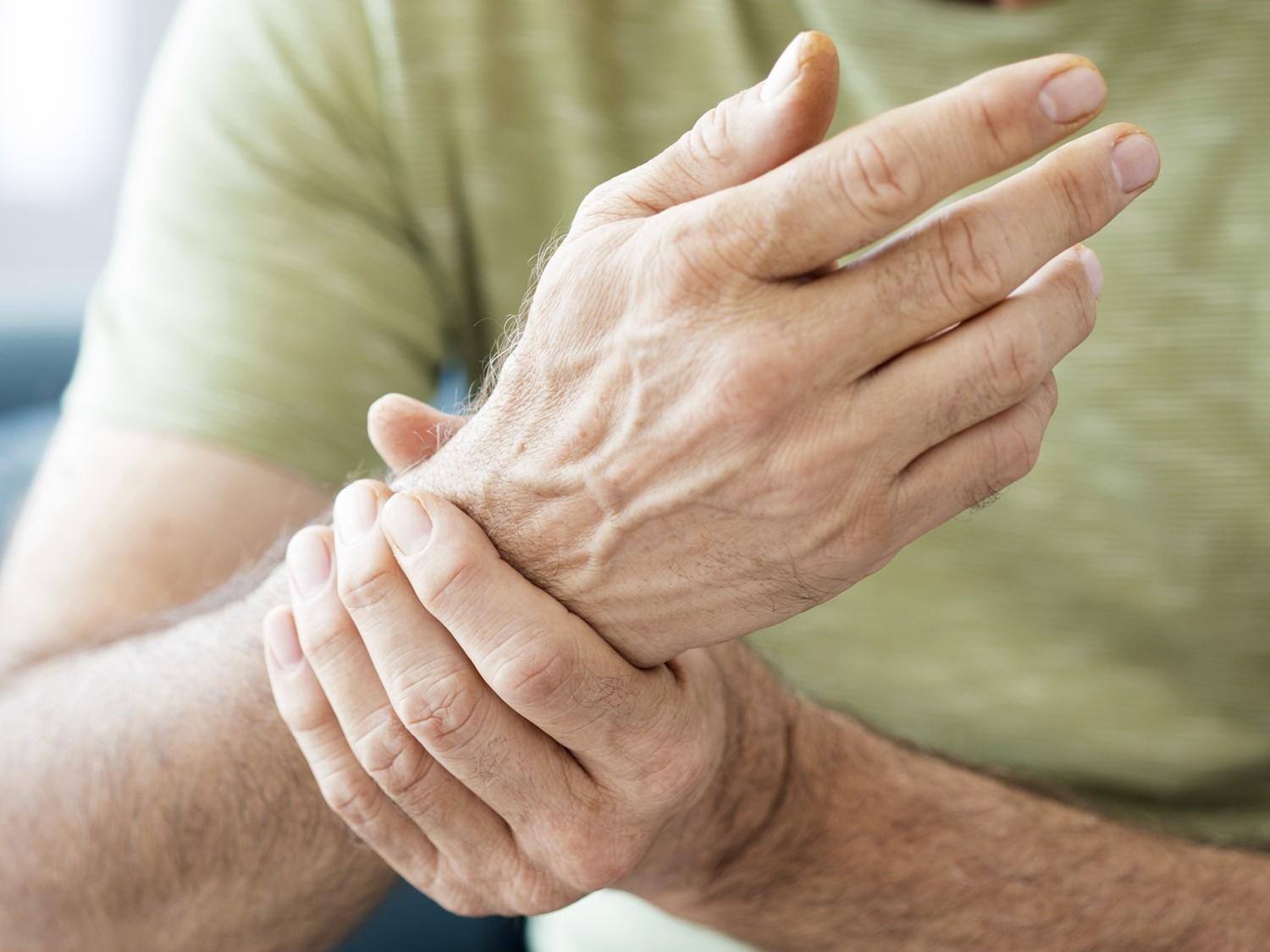 Photo of a person holding a arthritic wrist.