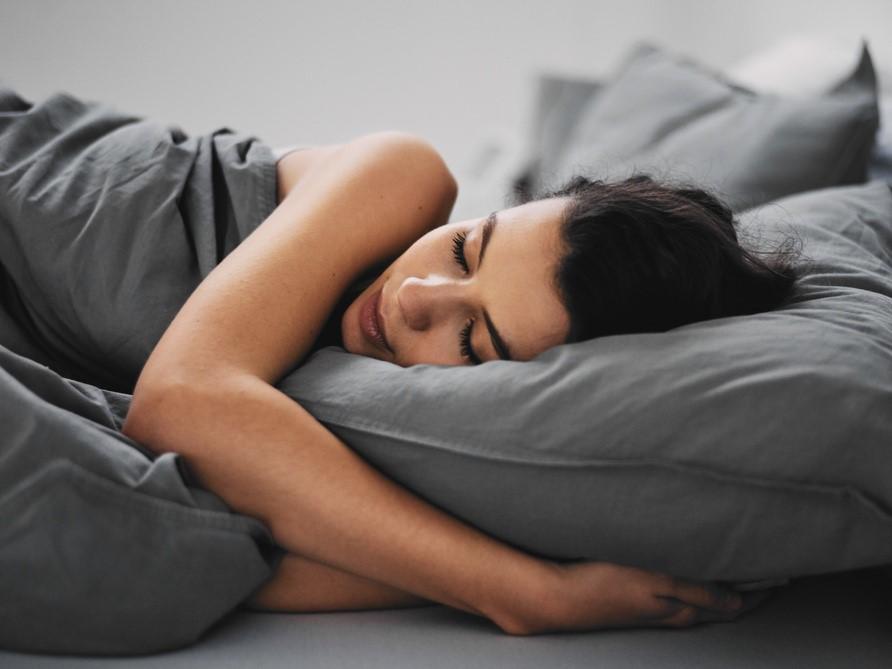 woman sleeping in grey bed