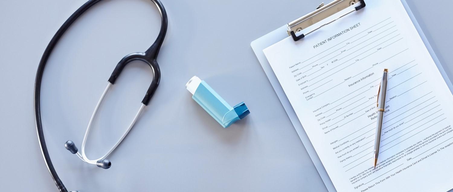Stethoscope, blue inhaler and patient information form with pen on light blue surface, representing medical care.